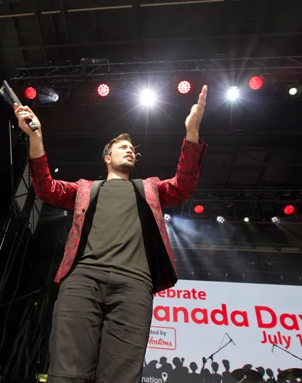 Magician performing on an event stage.