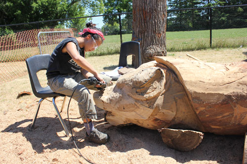 A student carving the Wolf Throne, which represents humility, one of the 7 Indigenous Grandfather Teachings.