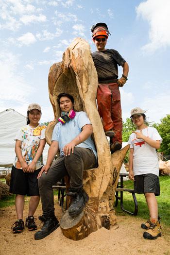 Shane Clodd and three students pose with one of the unfinished Markham Thrones.